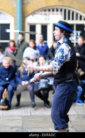 Giocoliere, giocoleria con coltelli per una folla nel mercato indoor di Covent Garden, Londra, Regno Unito Foto Stock