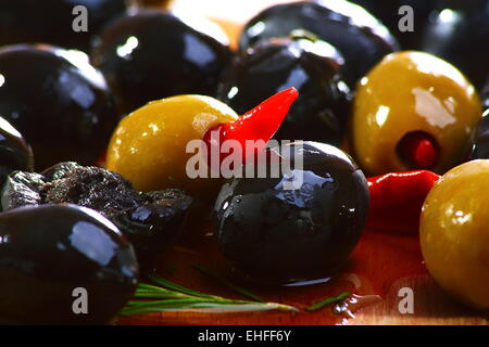 Olive nere e verdi su un tavolo di legno. Foto Stock