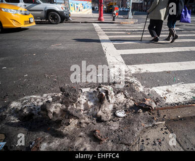 Sporco pezzi di ghiaccio, duro come il cemento, raccolti in numerose tempeste di neve e giorni di temperature di congelamento rimangono sul New York strade su Mercoledì, 11 marzo 2015 sfidando la recente pioggia e temperature calde. Temperature al 50's e seasonable temps in 40's più tardi questa settimana può causare i newyorkesi per l'addio a queste basse temperature memorie. (© Richard B. Levine) Foto Stock