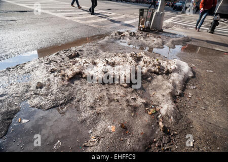 Sporco pezzi di ghiaccio, duro come il cemento, raccolti in numerose tempeste di neve e giorni di temperature di congelamento rimangono sul New York strade su Mercoledì, 11 marzo 2015 sfidando la recente pioggia e temperature calde. Temperature al 50's e seasonable temps in 40's più tardi questa settimana può causare i newyorkesi per l'addio a queste basse temperature memorie. (© Richard B. Levine) Foto Stock