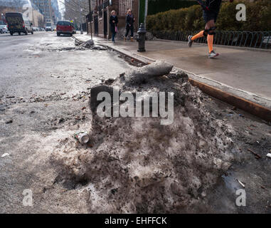 Sporco pezzi di ghiaccio, duro come il cemento, raccolti in numerose tempeste di neve e giorni di temperature di congelamento rimangono sul New York strade su Mercoledì, 11 marzo 2015 sfidando la recente pioggia e temperature calde. Temperature al 50's e seasonable temps in 40's più tardi questa settimana può causare i newyorkesi per l'addio a queste basse temperature memorie. (© Richard B. Levine) Foto Stock