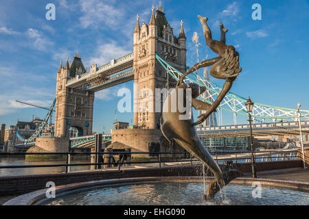 La scultura della ragazza e dolphin sulla riva nord del fiume Tamigi di fronte il Tower Bridge di Londra, Regno Unito - solo uso editoriale Foto Stock