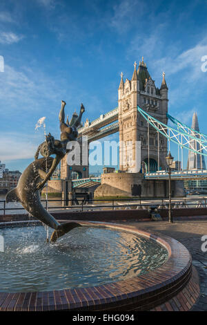 La scultura della ragazza e dolphin sulla riva nord del fiume Tamigi di fronte il Tower Bridge di Londra, Regno Unito - solo uso editoriale Foto Stock