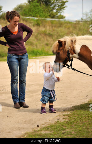 Mutter mit Kleinkind und Pony Foto Stock