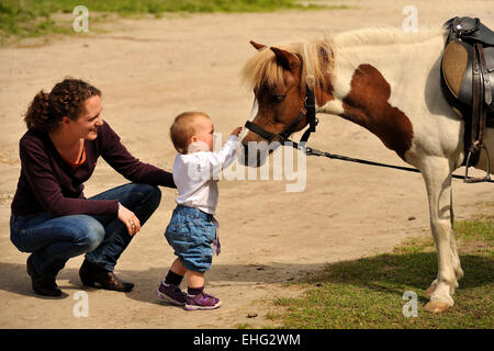 Mutter mit Kleinkind und Pony Foto Stock