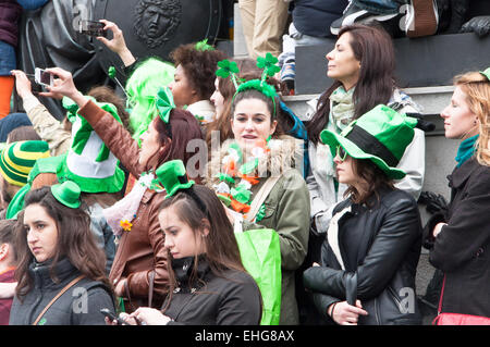 Ragazza in folla frequentando il il giorno di San Patrizio festival in O'Connell Street Dublino Irlanda indossando il verde delle orecchie dei conigli Foto Stock