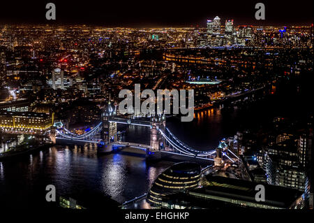 Una vista di Londra di notte guardando sopra la città di Londra con il Tower Bridge e la città di Londra in primo piano Foto Stock