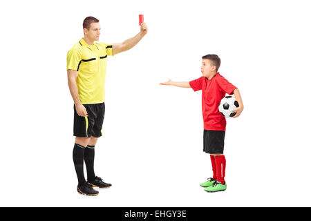 Arbitro di calcio che mostra la scheda di colore rosso per una junior soccer player isolati su sfondo bianco Foto Stock