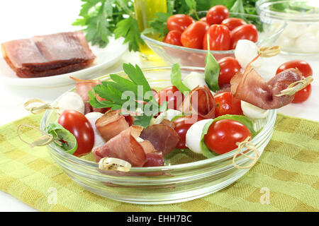 Pomodoro, mozzarella e prosciutto spiedini con basilico Foto Stock