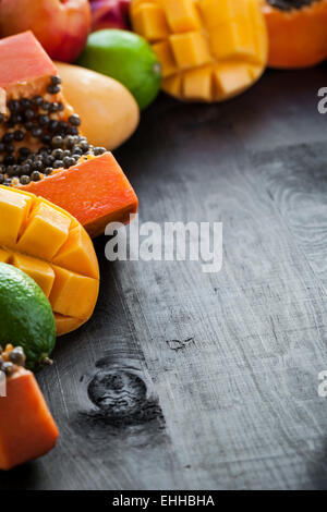 Un sacco di esotico fresco frutta tropicale su sfondo di legno con copyspace libero Foto Stock