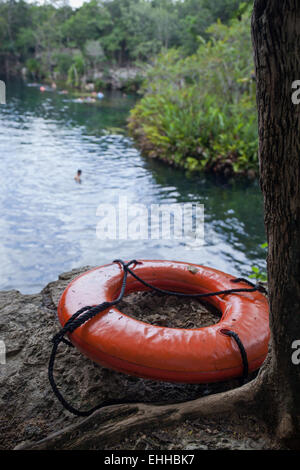 Orange salvagente sulle rocce con lo sfondo del lago Foto Stock