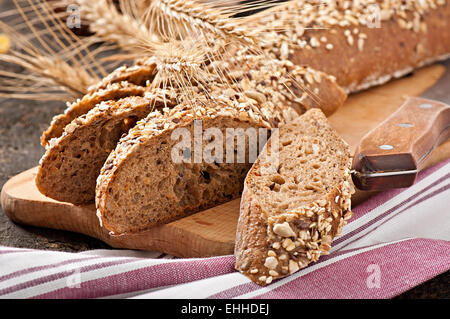 Fette di migliori pane organico decorate con spighe di grano. Foto Stock