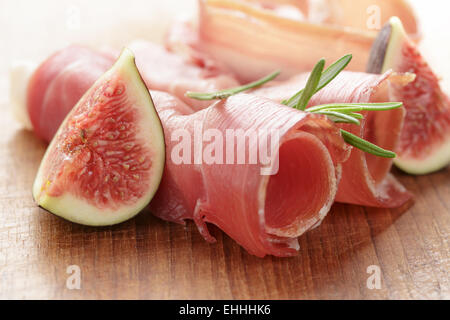 Crostini con prosciutto e fichi sul pannello di legno Foto Stock