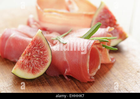 Crostini con prosciutto e fichi sul pannello di legno Foto Stock