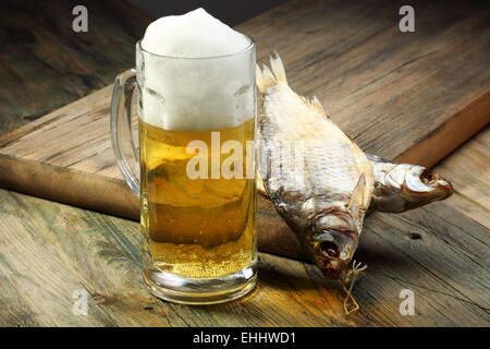 Vetro con birra e pesce essiccati. Foto Stock