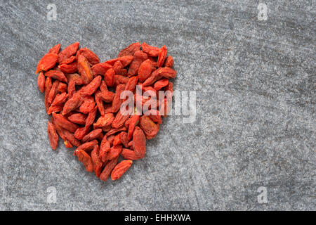 Cuore realizzato dal secco Tibetan Goji bacche su sfondo blackboard Foto Stock