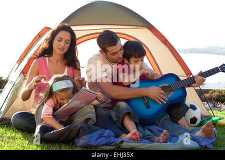 Famiglia di suonare una chitarra in una tenda Foto Stock