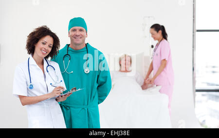 Giovane team medico in piedi vicino a un paziente Foto Stock
