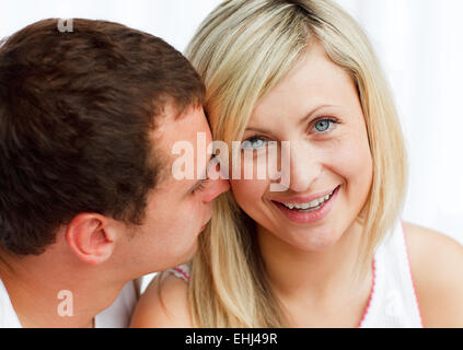 Whispering uomo una donna qualcosa di divertente Foto Stock