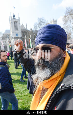 La piazza del Parlamento, Londra, Regno Unito. Il 14 marzo 2015. Un manifestante solitario è scortato dalla piazza. Statua in bronzo del Mahatma Gandhi da lo scultore britannico Philip Jackson, viene inaugurato nella piazza del Parlamento. Credito: Matteo Chattle/Alamy Live News Foto Stock