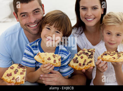 Ritratto di famiglia mangiare la pizza sul divano Foto Stock