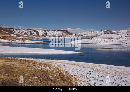 Montagne innevate che circonda parzialmente congelato blu Mesa serbatoio vicino Gunnison Colorado USA Foto Stock