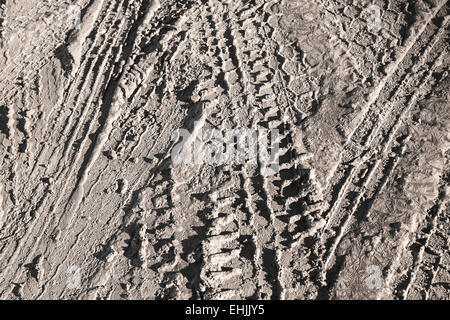 Texture di sfondo di colore marrone sporco su strada con tracce di pneumatici Foto Stock