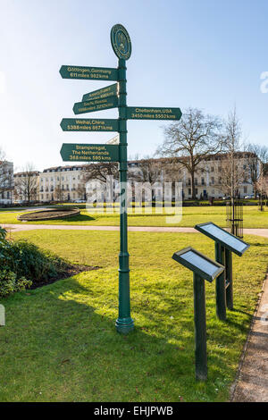 Un cartello nei giardini imperiali di Cheltenham, Gloucestershire che puntano alle città che sono gemellate con Cheltenham in tutto il mondo Foto Stock