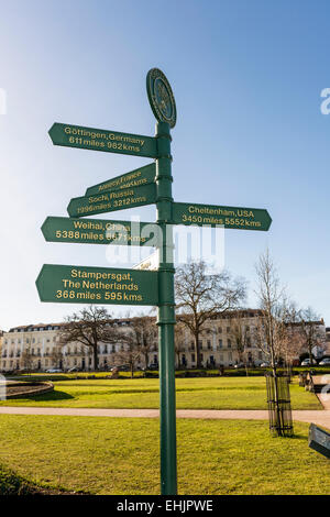 Un cartello nei giardini imperiali di Cheltenham, Gloucestershire che puntano alle città che sono gemellate con Cheltenham in tutto il mondo Foto Stock