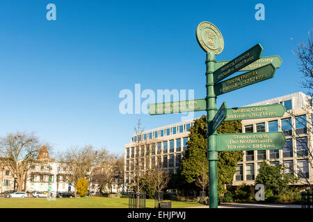 Un cartello nei giardini imperiali di Cheltenham, Gloucestershire che puntano alle città che sono gemellate con Cheltenham in tutto il mondo Foto Stock