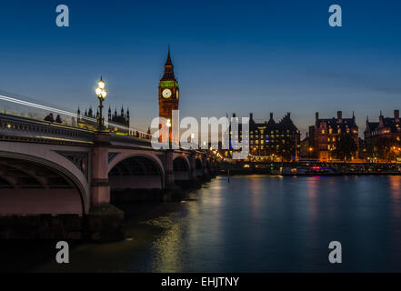 Big Ben e London skyline di notte sono illuminate e riflessa nel Tamigi, come il traffico passa sul Westminster Bridge . Foto Stock