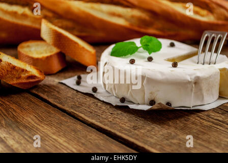 Tradizionale Francese di formaggio camembert con baguette sulla tavola di legno Foto Stock