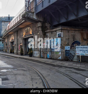 Negozi sotto il sovraccarico della linea ferroviaria e i binari del tram in una strada di Berlino Foto Stock