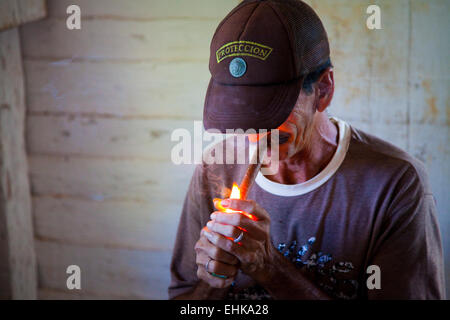 Un contadino cubano accende un sigaro, Vinales, Cuba Foto Stock