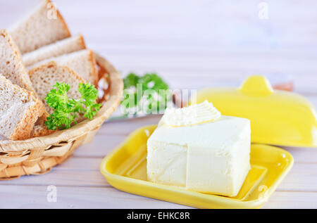 Il burro e il pane sulla tavola di legno Foto Stock