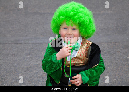 Giorno di San Patrizio in sedia a rotelle Daiton Berry Mellor (MR) 6 anni ragazzo, un sufferer spina bifida, che indossa una parrucca verde al Festival irlandese del fine settimana di San Patrizio. Migliaia di persone si sono schierate per le strade per assistere alla sfilata del giorno di San Patrizio che ha attraversato Manchester. La colorata processione parte dall'Irish World Heritage Centre a Cheetham Hill prima di arrivare a Albert Square. Foto Stock