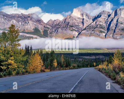 Road, nebbia e nuvole basse con colori autunnali. Il Parco Nazionale di Banff. Lo stato di Alberta, Canada Foto Stock