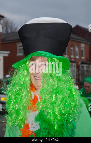 W oman indossa la parrucca verde e il cappello al Festival Irlandese del fine settimana di St Patrick. Migliaia di persone si sono schierate per le strade per assistere alla sfilata del giorno di San Patrizio che ha attraversato Manchester. La colorata processione parte dall'Irish World Heritage Centre a Cheetham Hill prima di arrivare a Albert Square. I portacolori di bandiera che rappresentavano le 32 contee dell'Isola di Smeraldo portarono la sfilata nel centro della città. Foto Stock