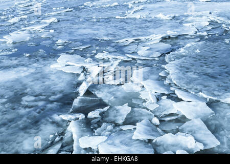 Grandi frammenti di ghiaccio coperto con spettacolo sul fiume congelato l'acqua. Blu scuro dello sfondo della natura Foto Stock