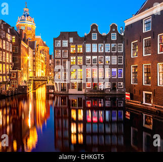 I canali di Amsterdam di notte vicino al quartiere a luci rosse. Basilica di San Nicolaaskerk di San Nicola, Zeedijk e il canale di Oudezijds Kolk Foto Stock