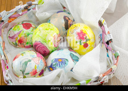 Grappolo di colorate a mano le uova di pasqua in una carta a mano cesto di uova Foto Stock