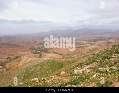 Vista panoramica delle colline di Fuerteventura Isole Canarie arido e secco con appena abbastanza impianti per le molte capre Foto Stock