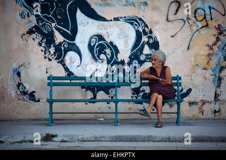 Una vecchia donna si siede sulla strada a l'Avana, Cuba Foto Stock