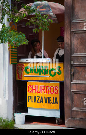 I venditori ambulanti vendono hot churros, Plaza Vieja, Havana, Cuba Foto Stock