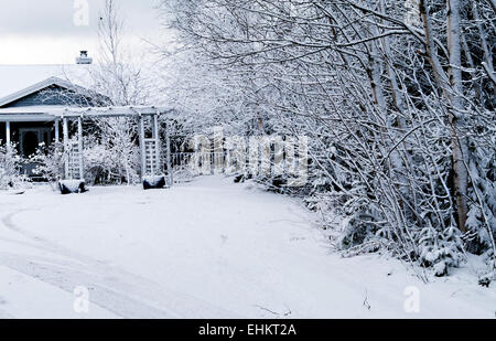 Coperta di neve a casa alla fine di un lungo viaggio in auto Foto Stock