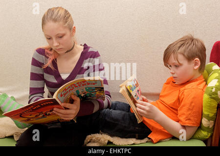 Ragazza adolescente e giovane ragazzo la lettura di libri di fumetti Foto Stock