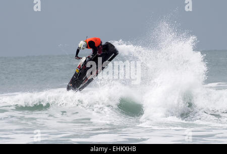 Maschio di jet ski concorrente esegue l'azione dell'antenna si sposta nella rottura grande surf su Newquay Fistral Beach Foto Stock