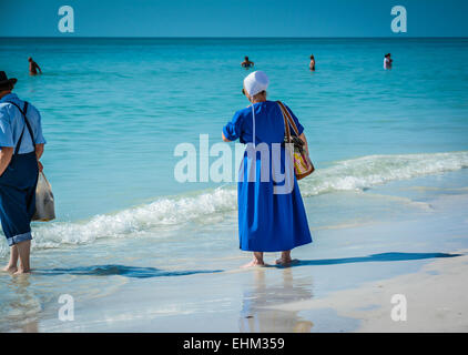 Amish, vestito nel loro modo tradizionale pagaia in shallow surf a Siesta Key Beach a Sarasota, FL Foto Stock