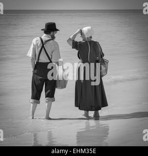 Black & White immagine di Amish giovane vestito nel loro modo tradizionale, godendo il surf a Siesta Key Beach a Sarasota, FL Foto Stock