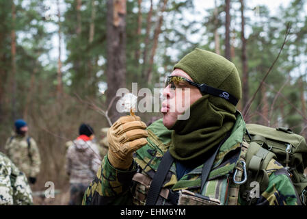 Kiev, Ucraina. Xv Mar, 2015. Soldato soffia a fiore al centro di formazione "Patriot', Kiev, Ucraina. 15 marzo, 2015. Credito: Oleksandr Rupeta/Alamy Live News Foto Stock